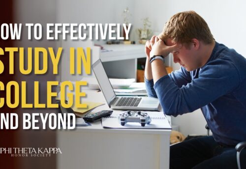 Student sitting at desk in front of laptop with head in his hands.